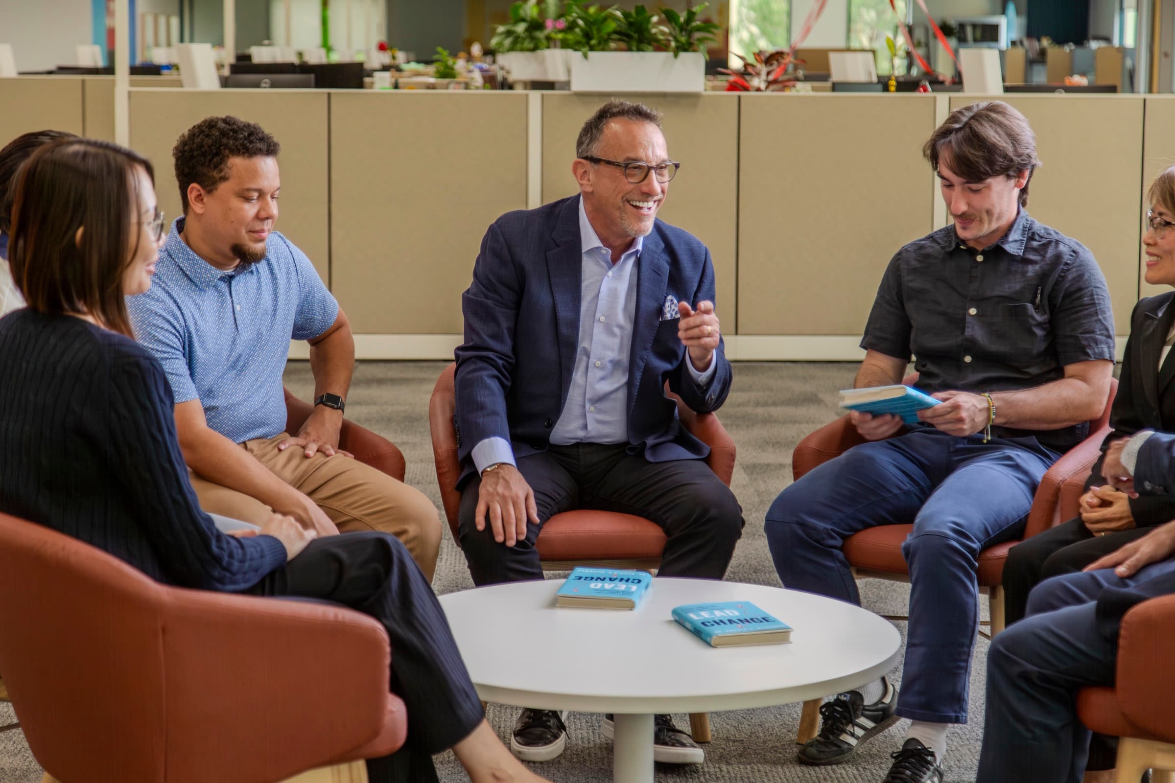 Ron Glickman leading a small cohort seated in a circle, copies of Lead for a Change on the table.